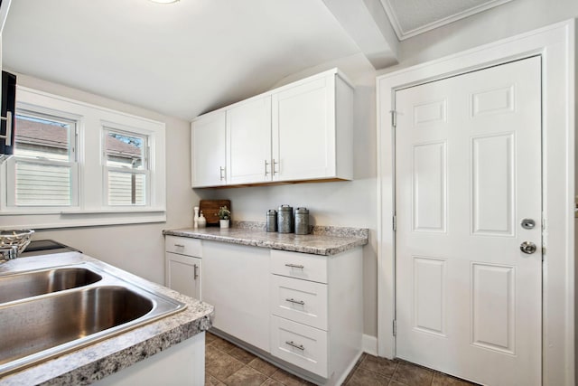 kitchen featuring light countertops, a sink, white cabinetry, and tile patterned floors