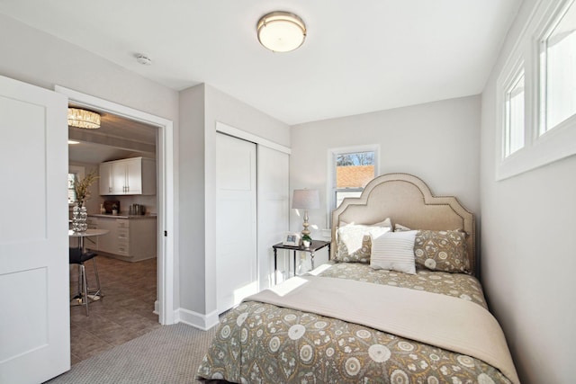 carpeted bedroom featuring a closet and baseboards