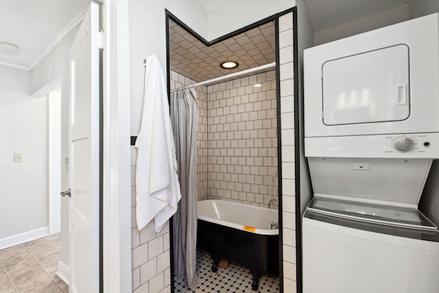 full bath with stacked washing maching and dryer, shower / bathtub combination with curtain, baseboards, and tile patterned flooring