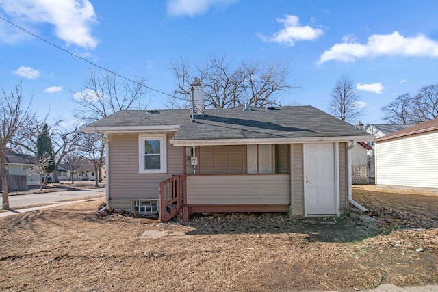 rear view of property with roof with shingles