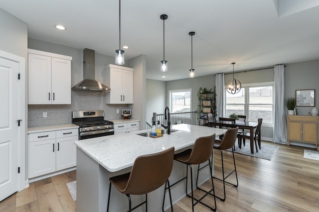 1676 Brandt Dr NE, Byron, MN 55920 - kitchen featuring a sink, light stone countertops, stainless steel range with gas cooktop, and wall chimney exhaust hood