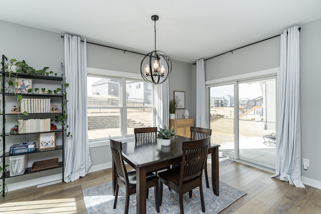 1676 Brandt Dr NE, Byron, MN 55920 - dining space with light wood-type flooring, baseboards, and a chandelier