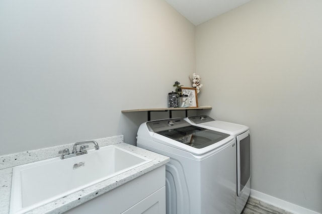 1676 Brandt Dr NE, Byron, MN 55920 - clothes washing area with light wood-style flooring, a sink, washing machine and dryer, baseboards, and laundry area