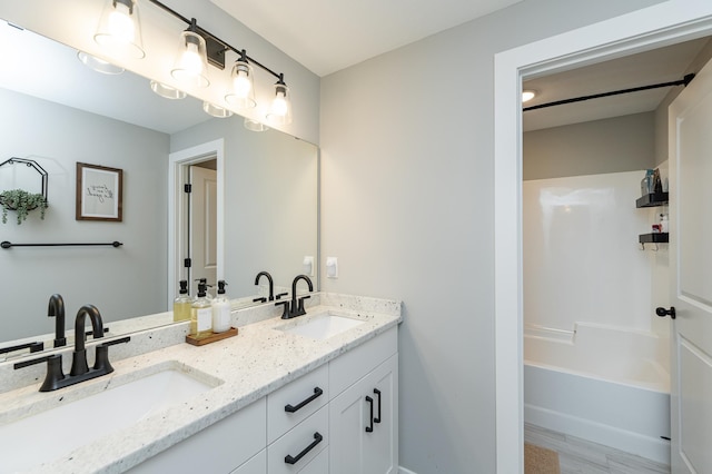 1676 Brandt Dr NE, Byron, MN 55920 - full bath with a sink, tub / shower combination, wood finished floors, and double vanity