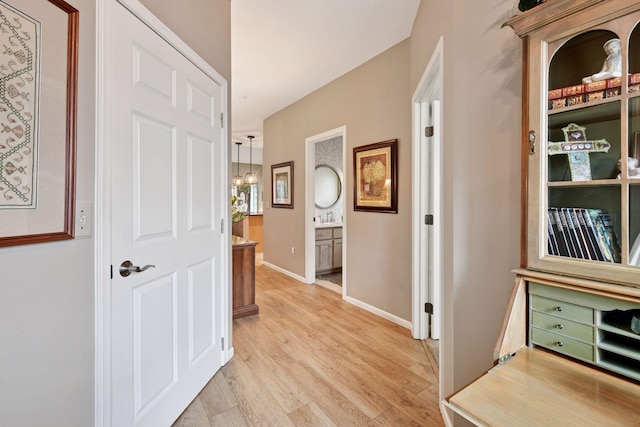 hall featuring light wood finished floors and baseboards