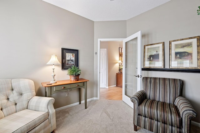 living area with light carpet and baseboards