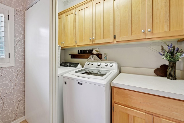 laundry area with independent washer and dryer, cabinet space, and wallpapered walls