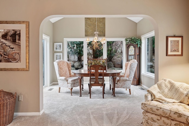 carpeted dining space featuring visible vents, arched walkways, baseboards, vaulted ceiling, and a chandelier