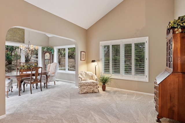 sitting room featuring carpet floors, arched walkways, high vaulted ceiling, a chandelier, and baseboards