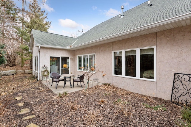 back of house featuring a patio area, a shingled roof, and stucco siding