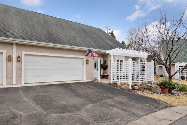 view of front of home with driveway, a shingled roof, an attached garage, and stucco siding