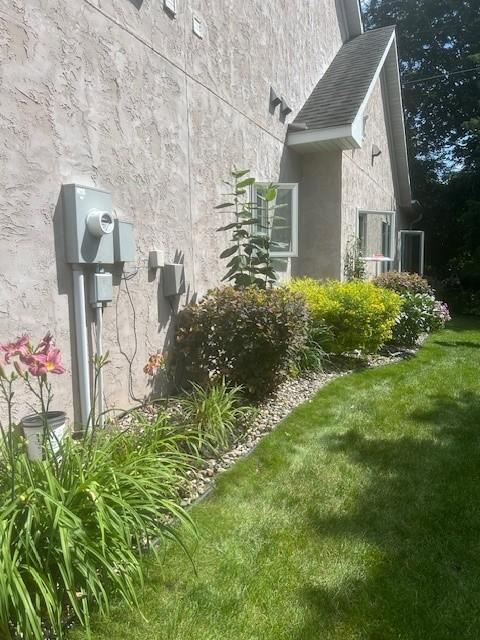 view of property exterior with a lawn and stucco siding