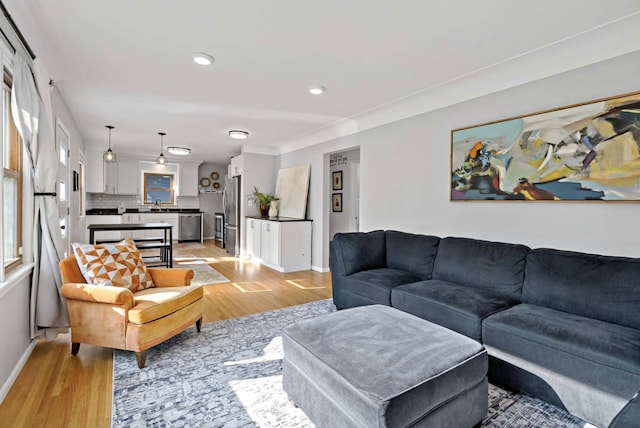 living room with light wood-style floors, baseboards, and recessed lighting