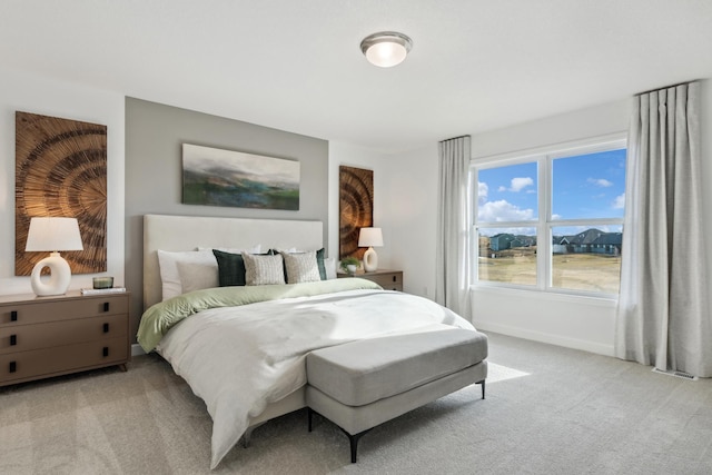 bedroom featuring light colored carpet and baseboards