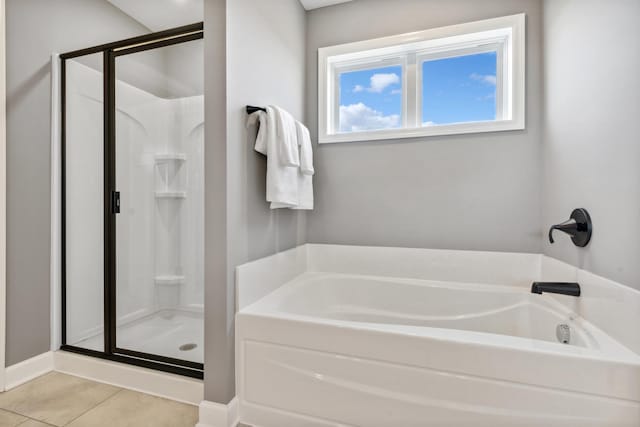 full bathroom featuring tile patterned flooring, a garden tub, and a shower stall