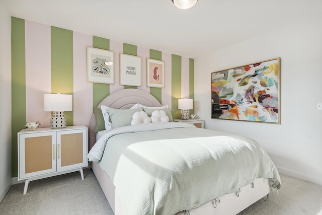 bedroom featuring light carpet, wallpapered walls, and baseboards