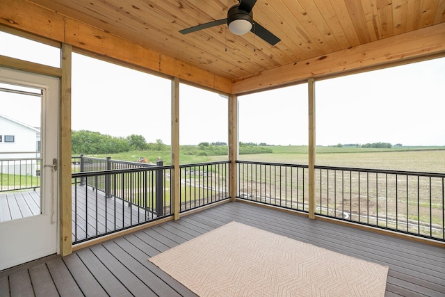 unfurnished sunroom with wooden ceiling, a rural view, and plenty of natural light