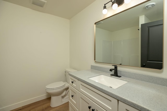 full bath featuring a shower, visible vents, toilet, vanity, and wood finished floors