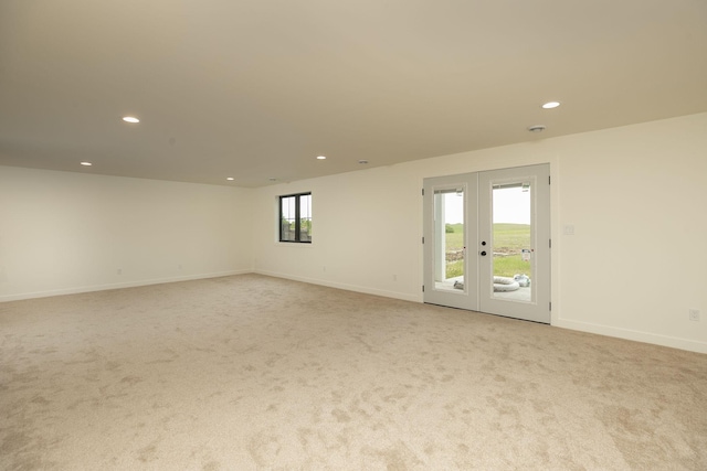 spare room featuring recessed lighting, french doors, light colored carpet, and baseboards