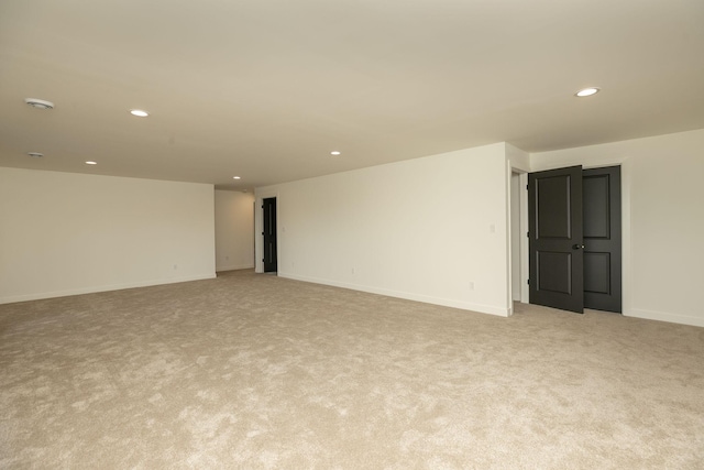 empty room with recessed lighting, light carpet, and baseboards