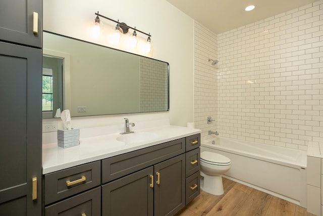 bathroom featuring recessed lighting, toilet, tub / shower combination, vanity, and wood finished floors