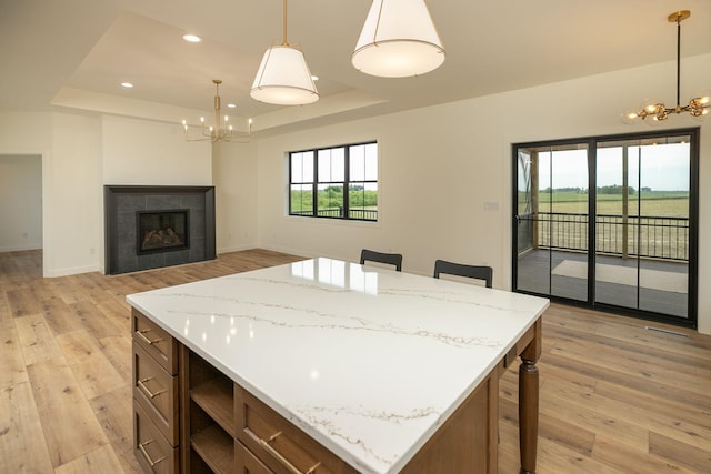 kitchen with a chandelier, a raised ceiling, and a center island