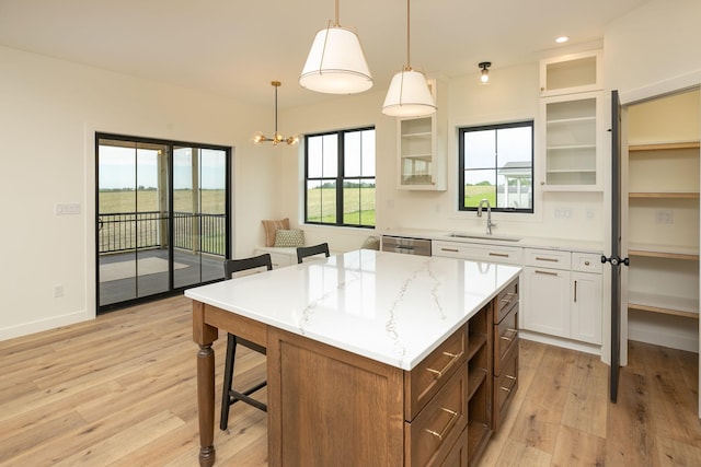 kitchen featuring a center island, open shelves, glass insert cabinets, white cabinets, and a sink