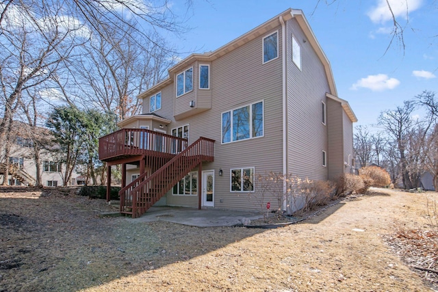 back of house with stairs, a deck, and a patio area