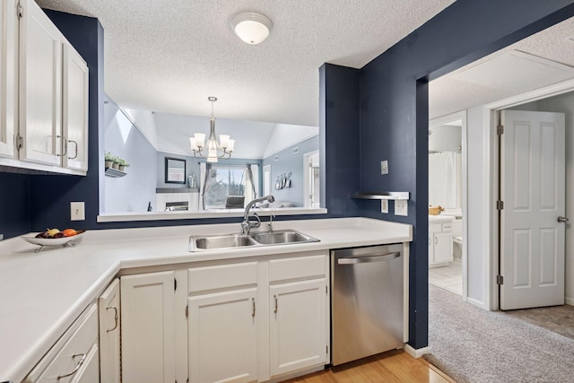 kitchen with a textured ceiling, lofted ceiling, a sink, light countertops, and dishwasher