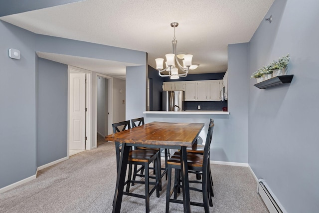 dining room featuring light carpet, baseboards, a baseboard heating unit, and a textured ceiling