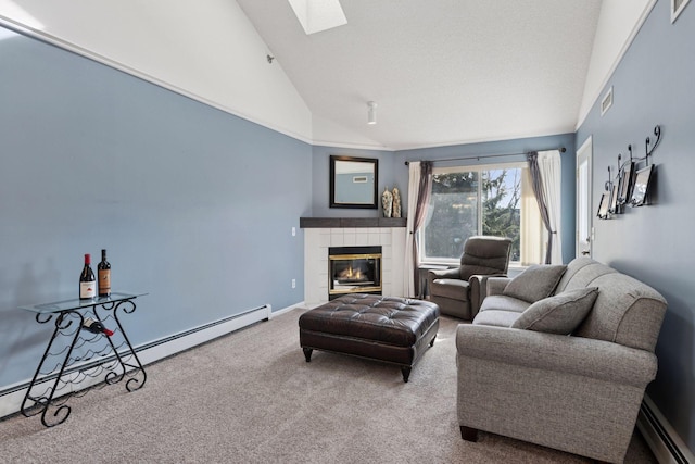 living room featuring carpet, a tiled fireplace, a skylight, and a baseboard radiator