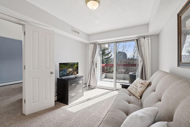 carpeted living area with a baseboard heating unit, a textured ceiling, and visible vents