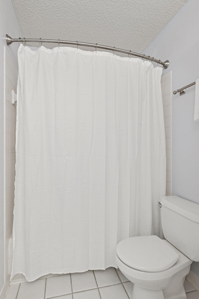 full bath featuring a textured ceiling, tile patterned flooring, and toilet