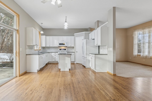 kitchen featuring a sink, white appliances, tasteful backsplash, and white cabinetry