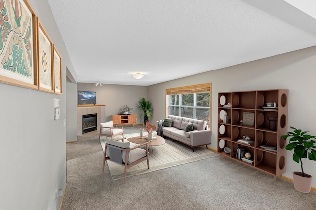 carpeted living area with a fireplace, baseboards, and a textured ceiling