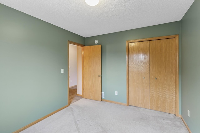 carpeted bedroom with baseboards, a closet, and a textured ceiling