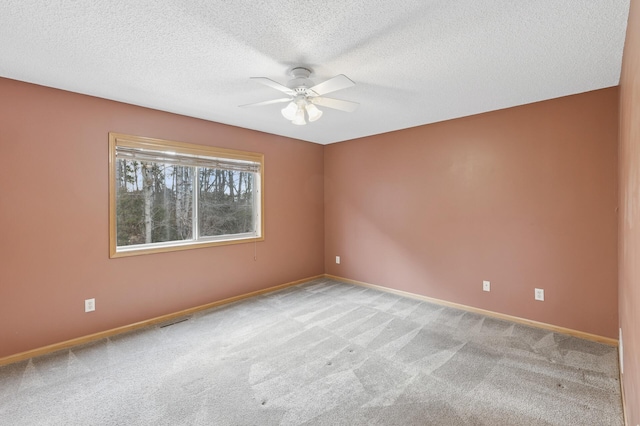 unfurnished room with visible vents, baseboards, carpet, and ceiling fan