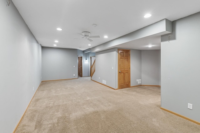 basement with light carpet, recessed lighting, stairway, baseboards, and ceiling fan