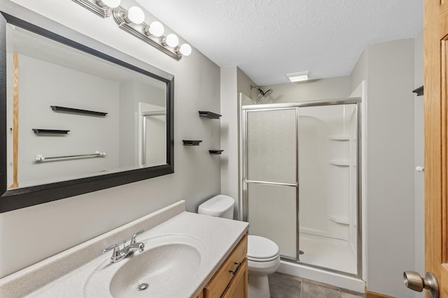 full bathroom with a shower stall, a textured ceiling, toilet, and vanity