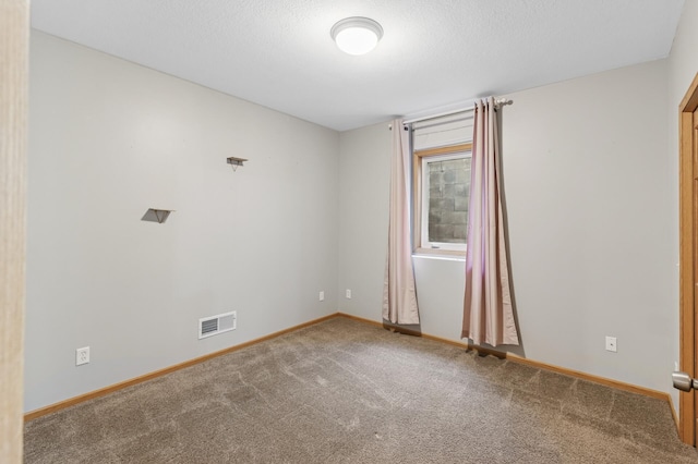 unfurnished room with visible vents, baseboards, a textured ceiling, and carpet flooring