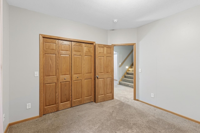 unfurnished bedroom featuring light colored carpet and baseboards