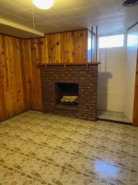 interior space with a fireplace, wood walls, and tile patterned floors