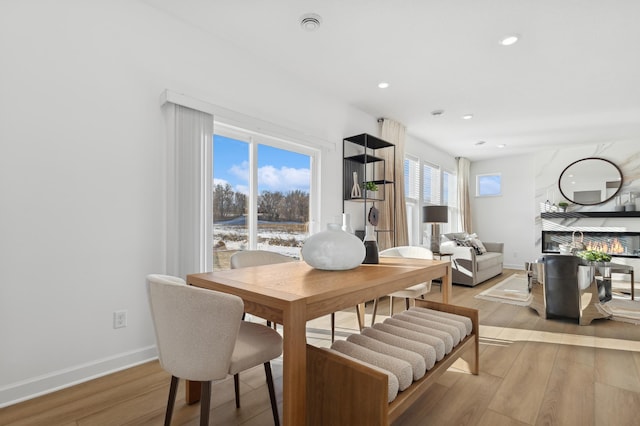 dining area featuring light wood-style flooring, baseboards, a wealth of natural light, and recessed lighting