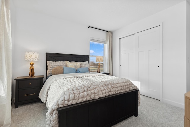 bedroom with light carpet, baseboards, and a closet