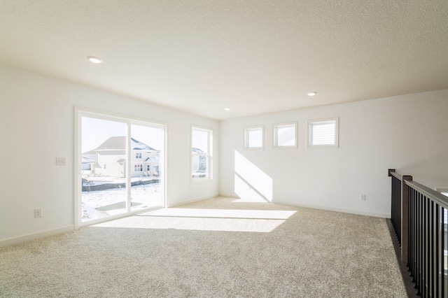 empty room featuring baseboards, carpet, and a healthy amount of sunlight