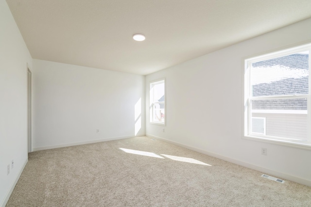 carpeted empty room with visible vents and baseboards