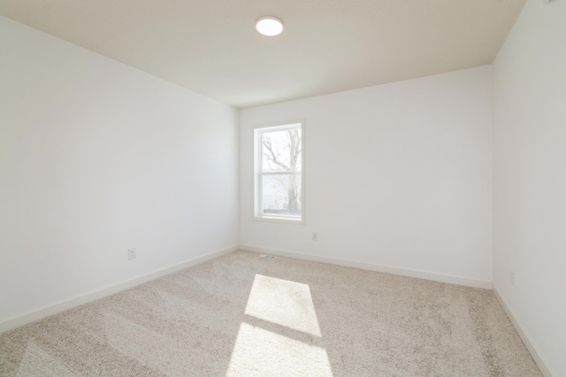 empty room with light carpet and baseboards