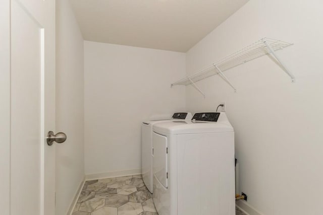 laundry room featuring laundry area, baseboards, and washer and clothes dryer