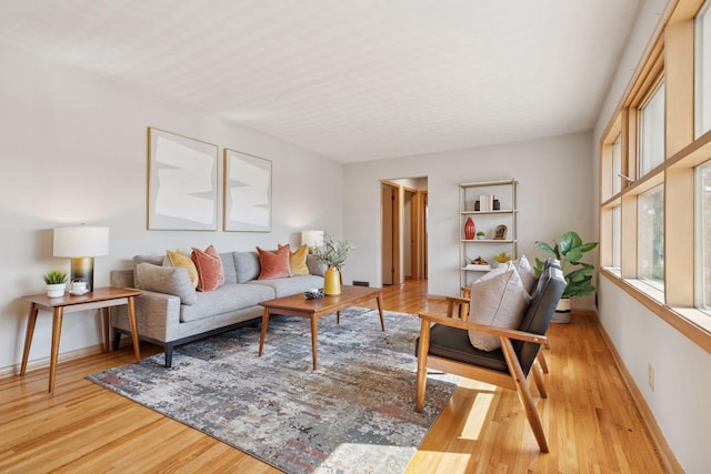 living room with baseboards and light wood-style floors