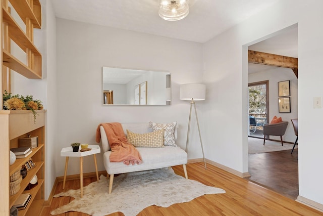 living area with baseboards and wood finished floors